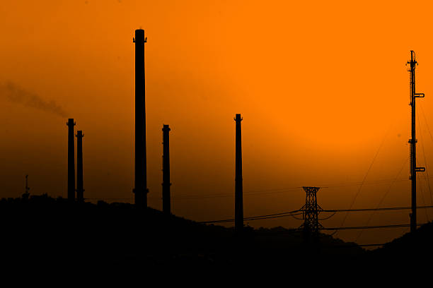 Oil refinery on Sunset background - Stock Photo