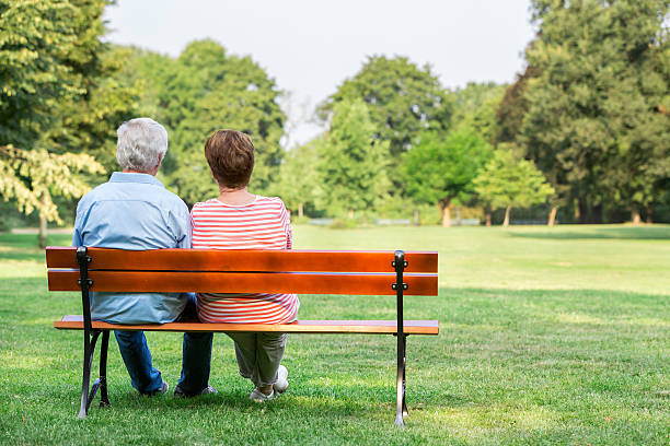 istock Senior adults outdoors in the park on park bench 487022512