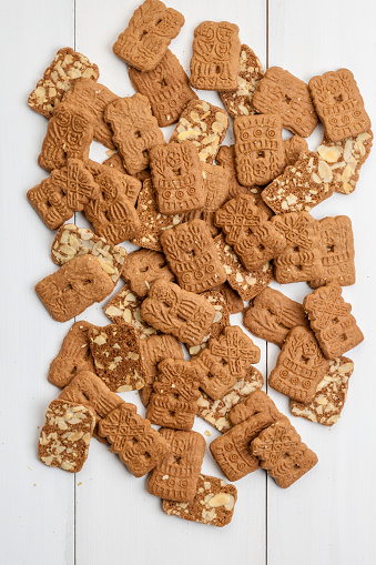 dutch speculaas biscuits and spices on a white washed wooden background