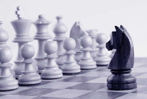 Caballo negro al blanco piezas de ajedrez en el tablero de ajedrez photo