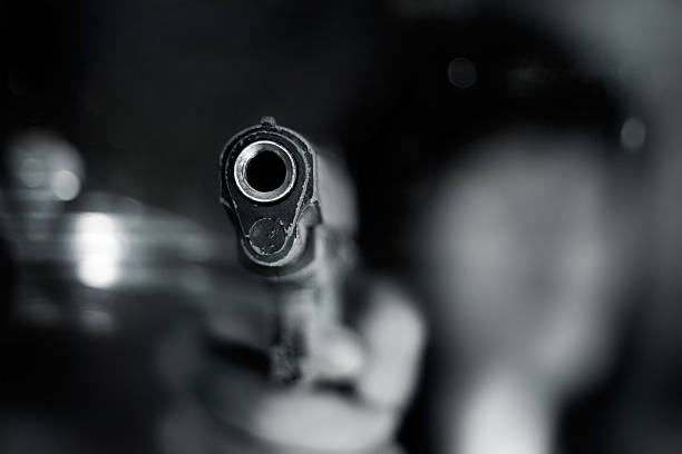 blanco y negro, mujer señalando old pistola en la parte delantera - target shooting fotografías e imágenes de stock