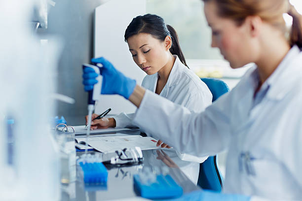 scientists working in modern laboratory - women scientist indoors science imagens e fotografias de stock