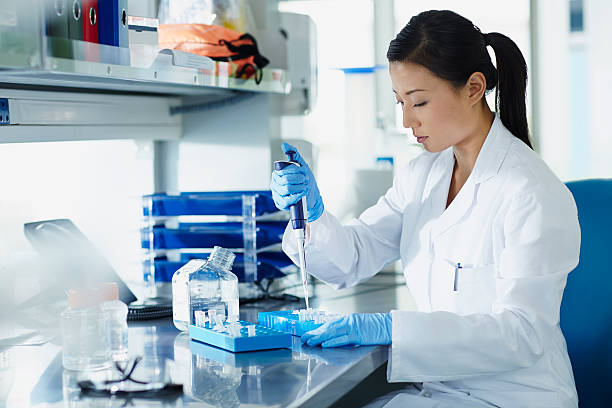 scientist pipetting samples into eppendorf tubes - science women female laboratory imagens e fotografias de stock
