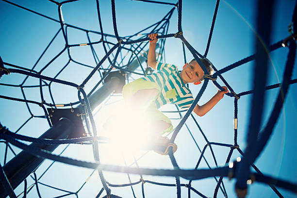 istock Little boy playing on the playground climbing web 487044886