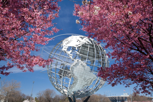 New York City, USA - April 20, 2014: The Unisphere with cherry blossom trees in Flushing Meadows Corona Park at New York City.