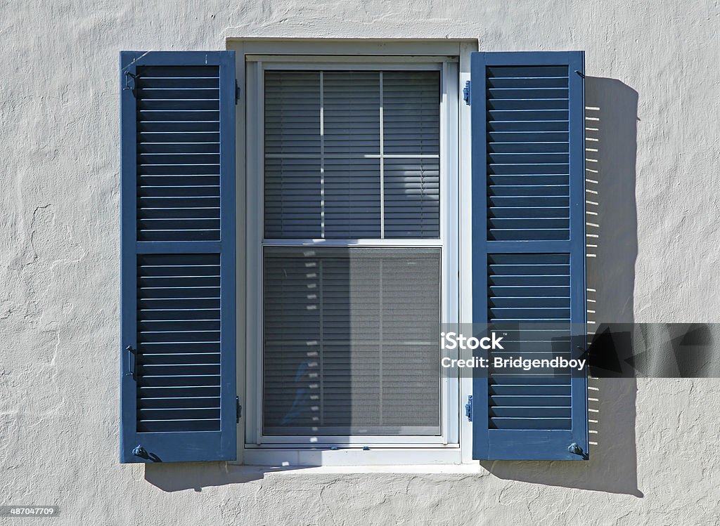 Open Blue Window Shutters Open blue window shutters, against a white wall, in a hot country Shutter Stock Photo