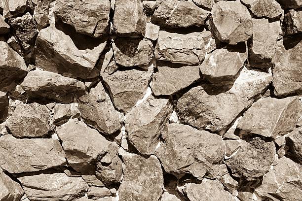 Fragment of the stone wall with moss. Sepia toned. Background for design.