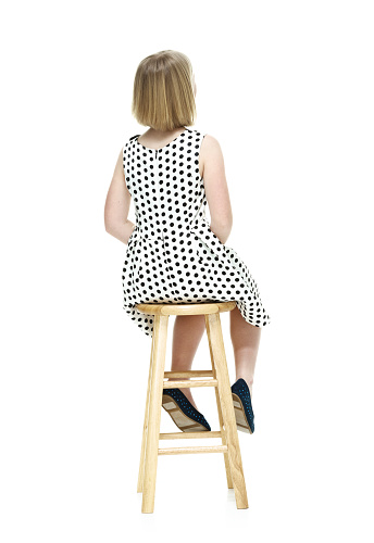 Rear view of little girl sitting on stoolhttp://www.twodozendesign.info/i/1.png