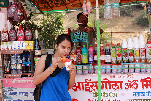 Matheran, India - February 2, 2014: A girl tourist eating ice candy in Matheran hill station in India.