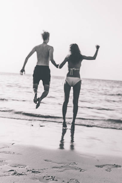 istock Young Couple jumping on the Beach 487051383