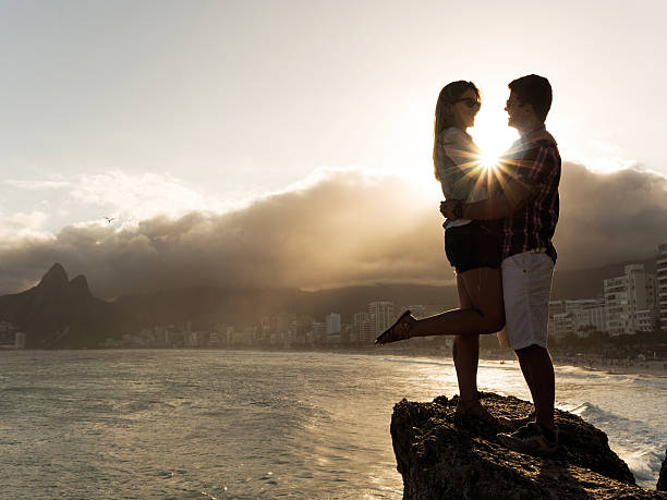 istock Loving embraced couple communicating on a rock at sunset. 487053646