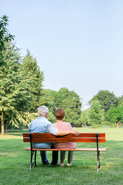 istock Senior adults outdoors in the park on park bench 487054236