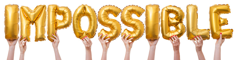 The word impossible has been created by female hands holding individual letter balloons. Each balloon is being held against a plain white background by a caucasian female hand. The Balloons are inflated and made from a shiny reflective gold material.