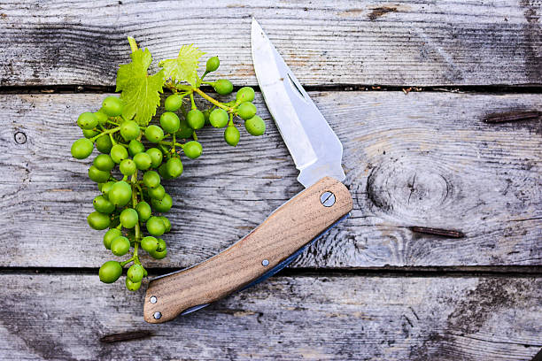 green grapes and knife on wood table