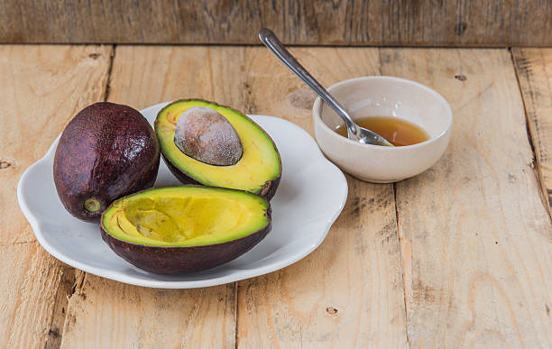 istock Avocado cut in half on a wooden floor. 487068344
