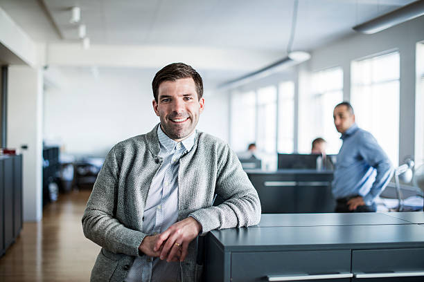 istock Happy businessman leaning on cubicle in office 487072260