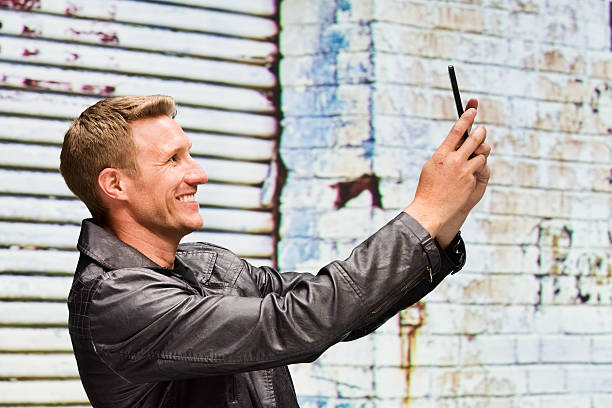 istock Smiling man taking a selfie outdoors 487076974