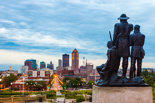 Downtown Des Moines, Iowa with the Pioneers of the Territory statue in the foreground.  The statue was made by Karl Gerhardt in 1892.