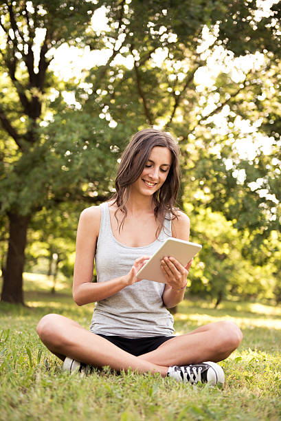 istock Young woman with digital tablet at the park 487077520