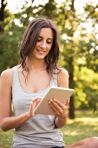 istock Young woman with digital tablet at the park 487077524