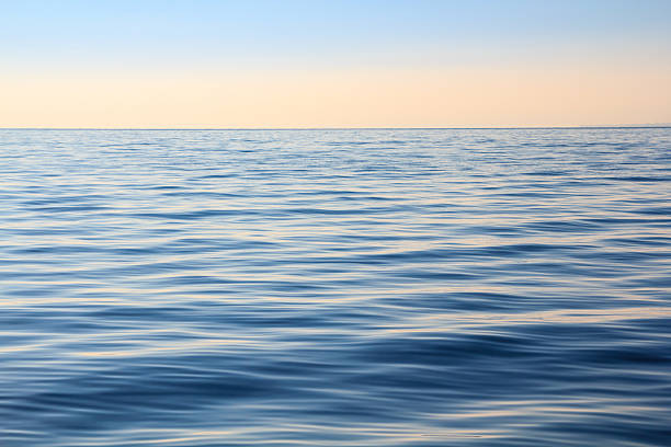 istock fluid waves blue sea and sunset sky background 487078219