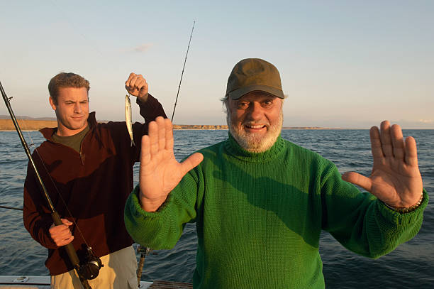 pai contar história de peixe - fishing active seniors family senior adult imagens e fotografias de stock