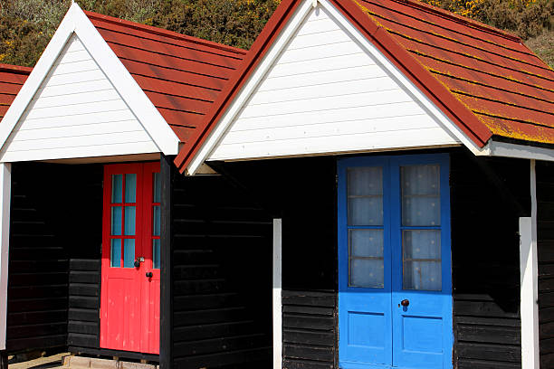 istock Image of colourful English painted beach huts next to cliff 487081069