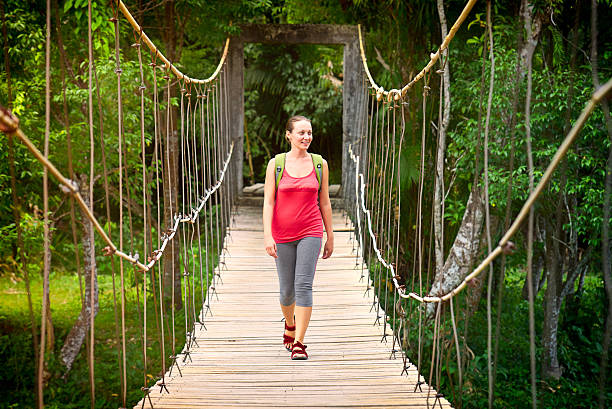 istock Smiling woman hiker crossing suspension bridge 487081154