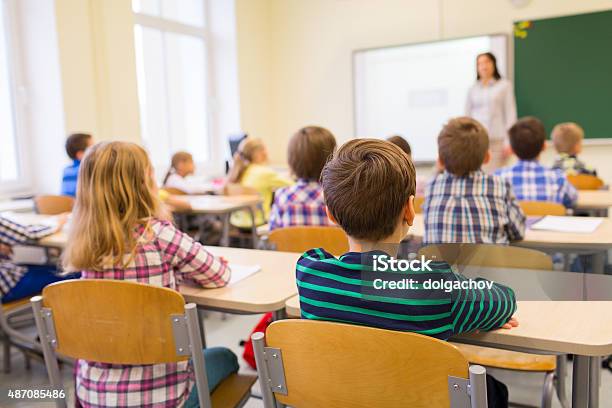 Group Of School Kids And Teacher In Classroom Stock Photo - Download Image Now - Classroom, Child, Rear View