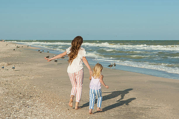 istock Mother and her daughter  having fun on the beach 487085508