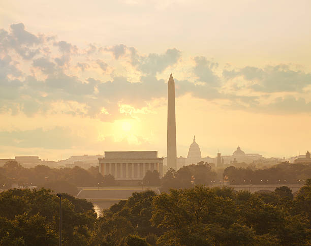 Washington DC skyline with sun and clouds in the morning Washington DC skyline with sun and clouds in the morning showing the Lincoln Memorial, the Washington Monument and the Capitol washington monument washington dc stock pictures, royalty-free photos & images