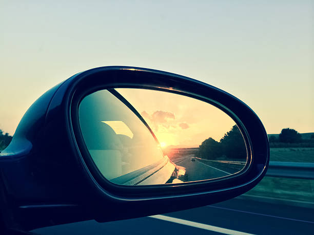 Sunset in a rear view mirror stock photo