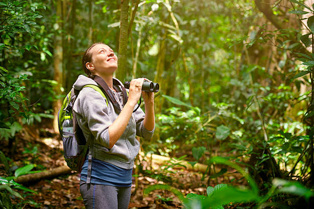 istock Hiker watching through binoculars wild birds in jungle. 487096534