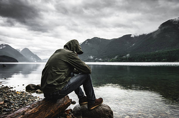 Solitude man pensive on the lake side Solitude man pensive on the lake side spirituality adventure searching tranquil scene stock pictures, royalty-free photos & images