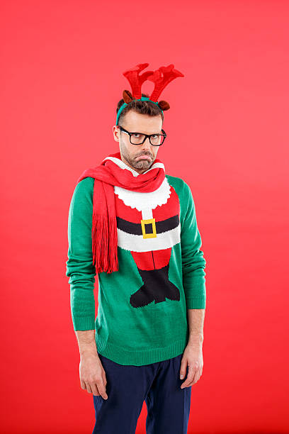 istock Sad nerd man in funny winter outfit against red background 487100060