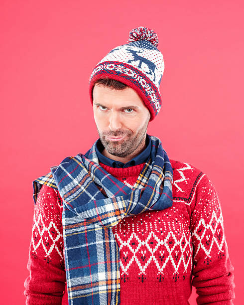 istock Happy man in winter outfit against red background 487100140