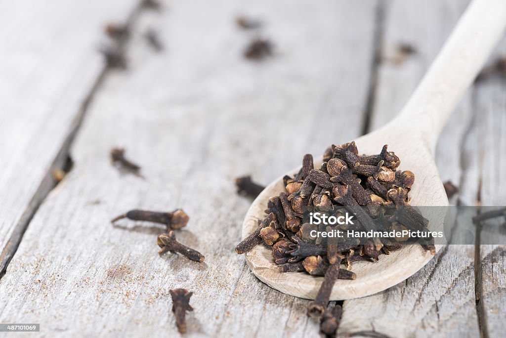 Cloves on a wooden spoon Small portion of Cloves on a wooden spoon (close-up shot) Clove - Spice Stock Photo