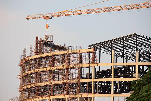 Derrick cranes in construction site at sunset time stock photo