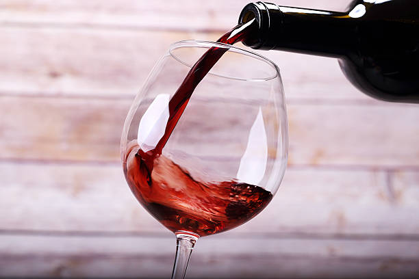 Pouring wine into glass and background stock photo