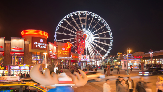 Niagara Falls, Canada - April 18, 2014: Main Plaza and the SkyWheel in Niagara Falls, Canada. iagara SkyWheel is a 175-foot tall Ferris wheel in the middle of Clifton Hill, Niagara Falls, Ontario, Canada. It opened on 17 June 2006, at cost of $10 million
