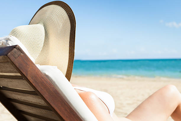 istock Woman Sunbathing On Deck Chair At Beach 487103444