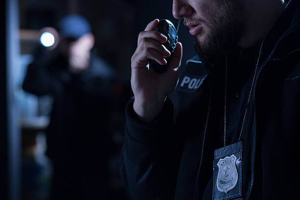 Officer using walkie talkie Officer using walkie talkie during police intervention walkie talkie photos stock pictures, royalty-free photos & images