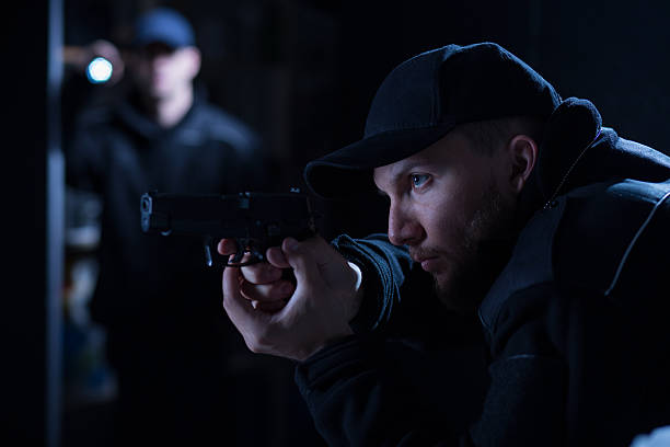 istock Police officer holding handgun 487104694
