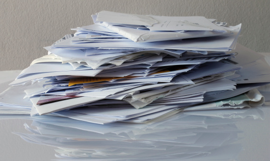 Pile of paper on reflective white surface