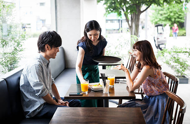 istock Waitress serves asian couple in cafe 487105032