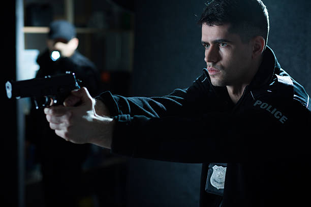 istock Police officer with handgun 487107492