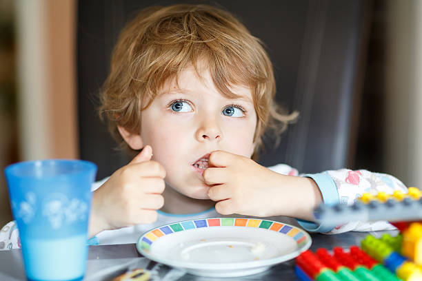 istock Little kid boy drinking milk and playing with construction block 487108582