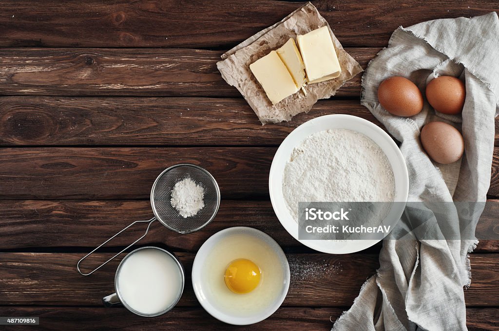 ingredients for making pancakes or cake ingredients for making pancakes or cake - flour, egg, butter, milk on  the old wooden background. top view. rustic or rural style. background with free text space.  Ingredients for the dough. Pancake Stock Photo