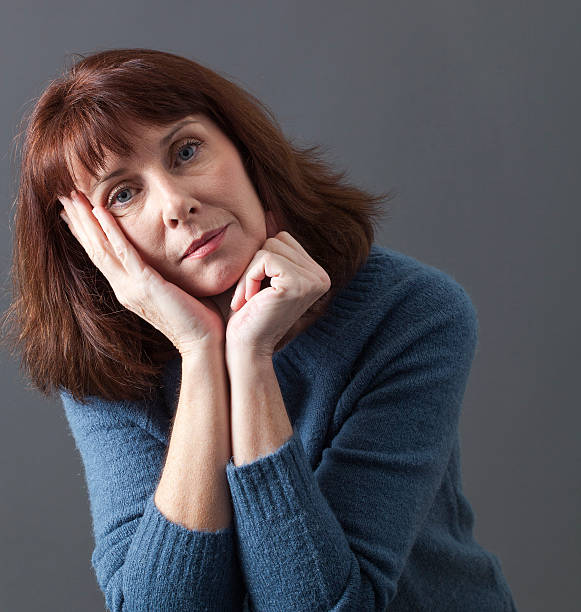 istock thinking mature woman looking under shock for winter season 487112254