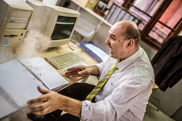 istock Man sitting near a computer emitting smoke 487113800
